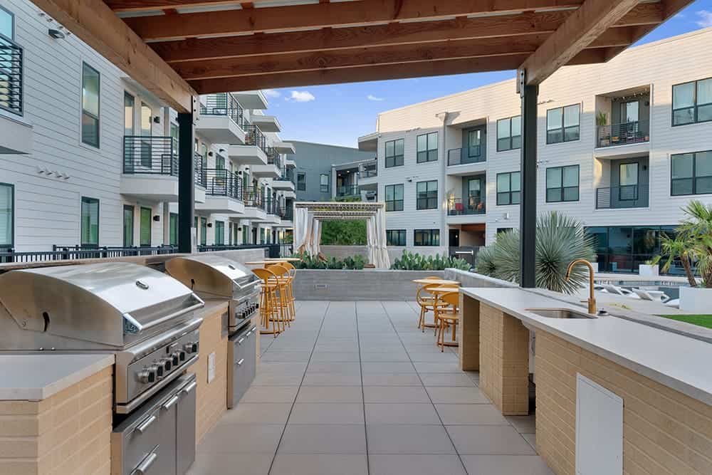 Outdoor kitchen with grills, seating, and scenic views at Parkside at Mueller.
