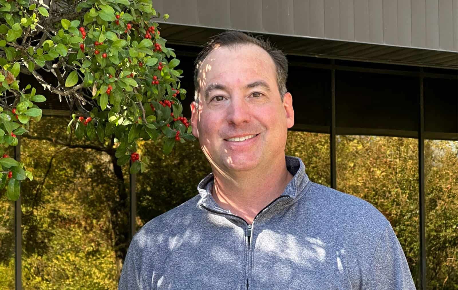 Brian Arthur smiling outdoors at Benkendorfer Associates, showcasing professional expertise in a nat.