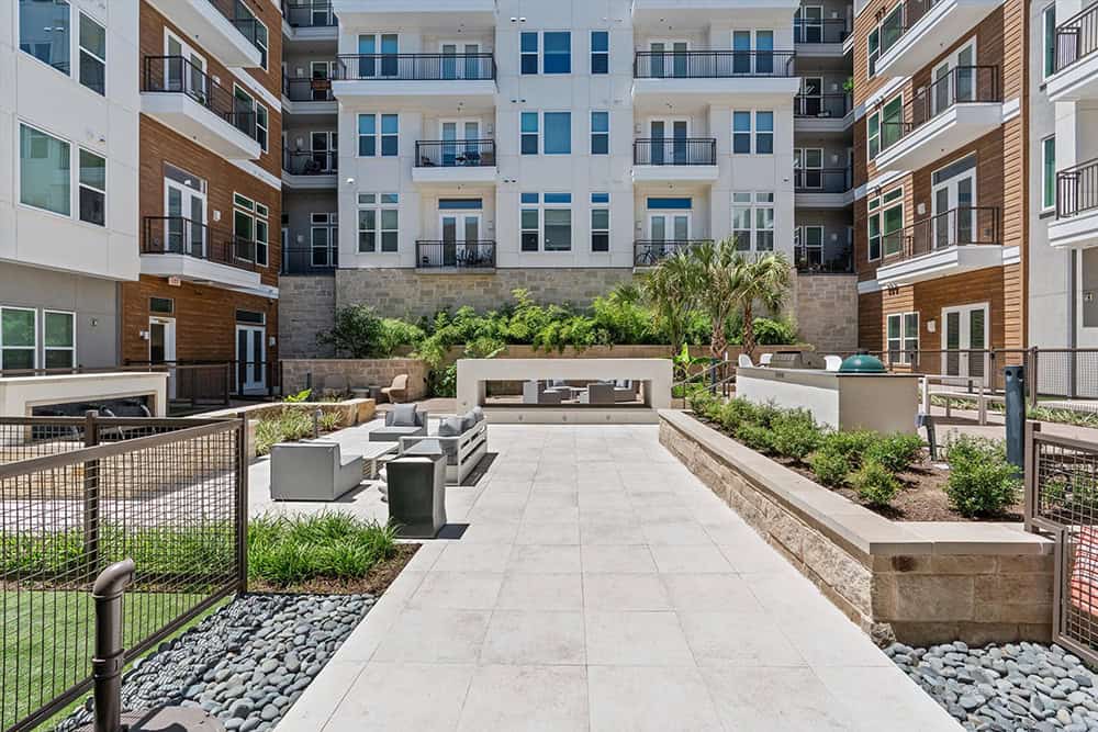 Contemporary apartment courtyard with seating and landscaping features.