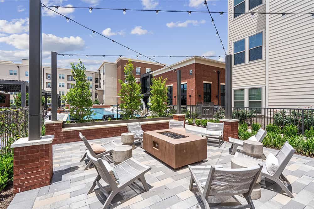 Modern outdoor lounge with seating and string lights at Gramercy at Northline.