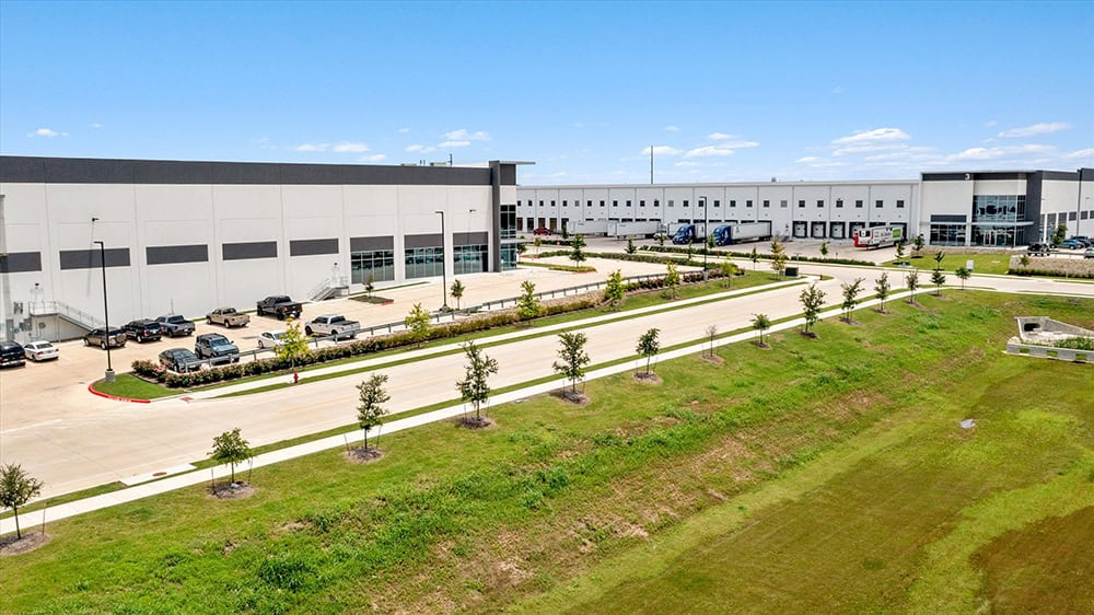 Modern warehouse building with parking lot and landscaped area.