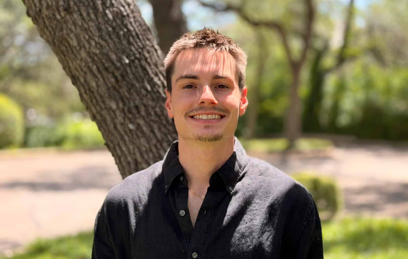 Portrait of Ethan Hoermann outdoors with trees in background.